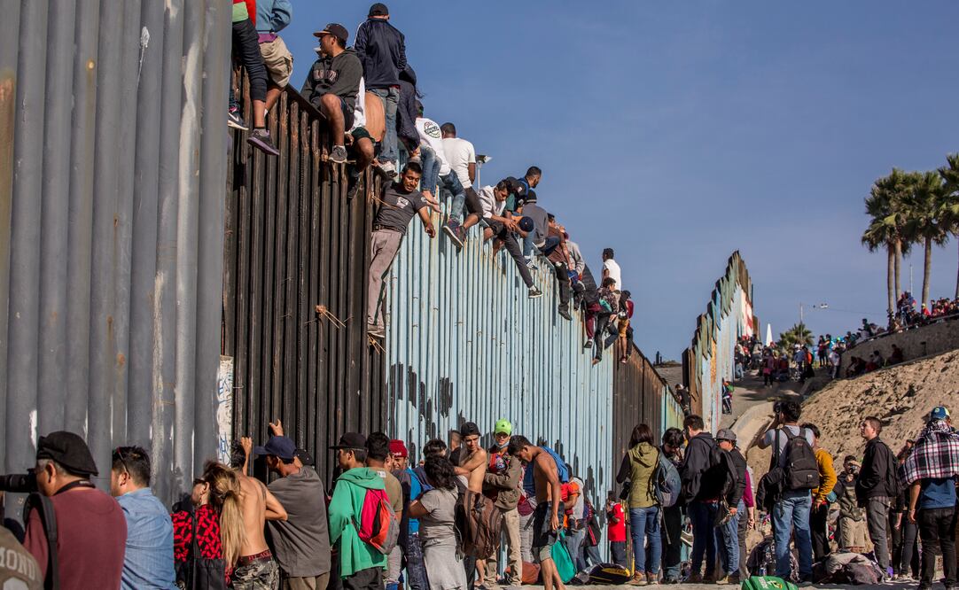 Algunos migrantes treparon el muro fronterizo y ante los agentes de EU que custodian la zona gritaron: “¡No somos delincuentes!”. (Omar Martínez CUARTOSCURO)