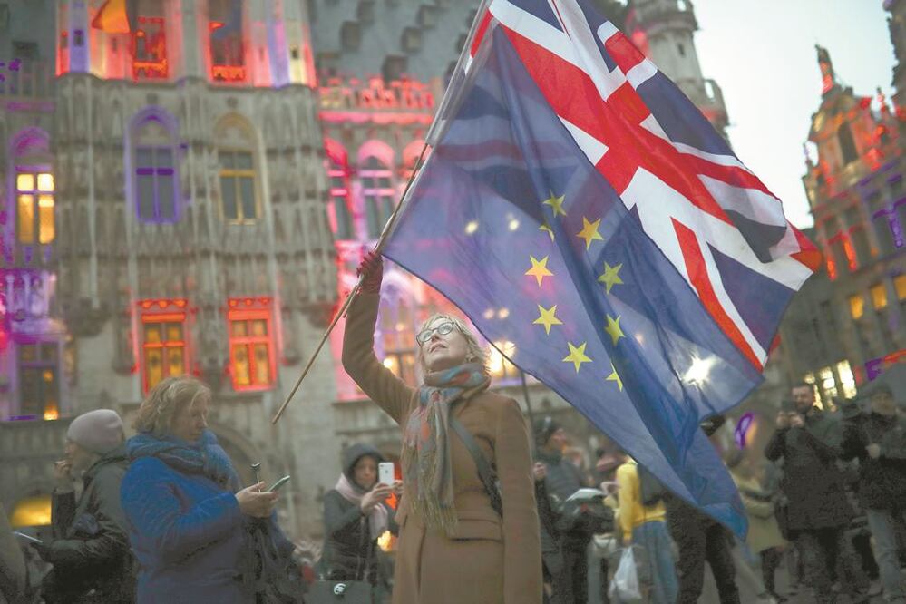 Una mujer sostiene las banderas del Reino Unido y de la Unión Europea, en un evento para celebrar la amistad entre Bruselas y los británicos. FRANCISCO SECO. AP