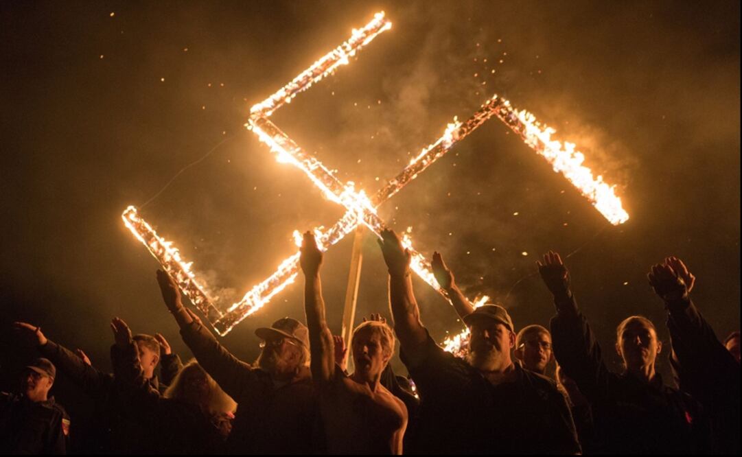 Supporters of the National Socialist Movement, a white nationalist political group, give Nazi salutes while taking part in a swastika burning at an undisclosed location in Georgia - Photo: Go Nakamura/REUTERS