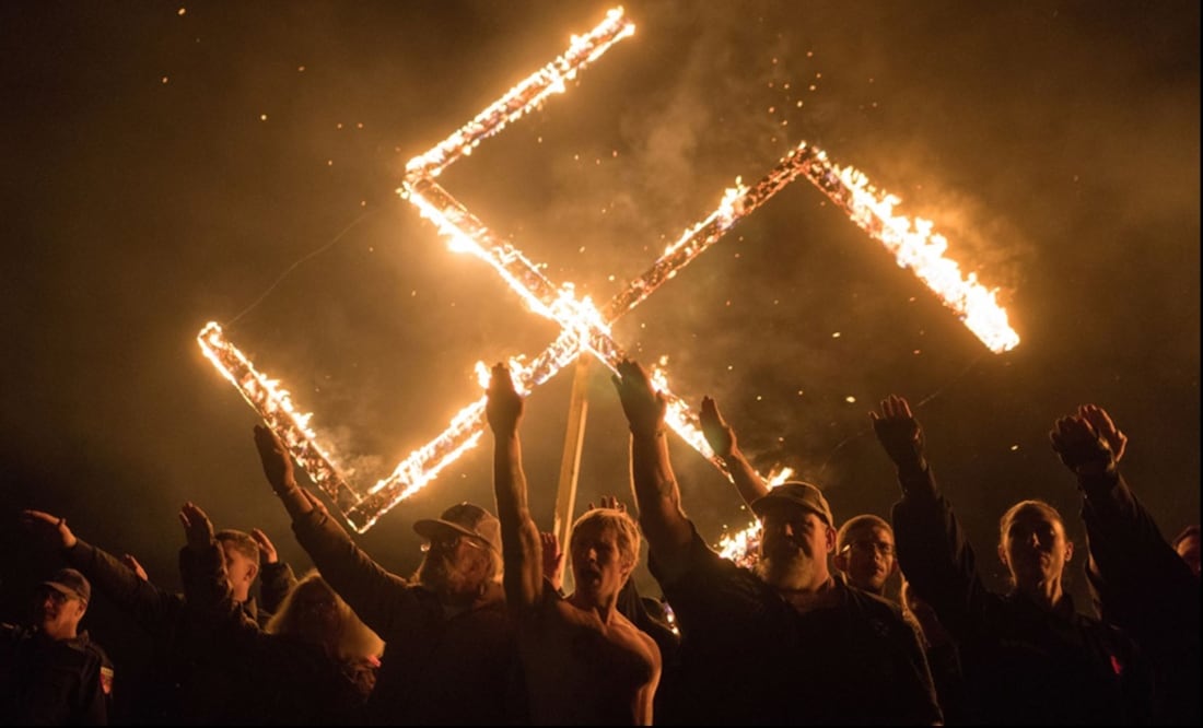 Supporters of the National Socialist Movement, a white nationalist political group, give Nazi salutes while taking part in a swastika burning at an undisclosed location in Georgia - Photo: Go Nakamura/REUTERS