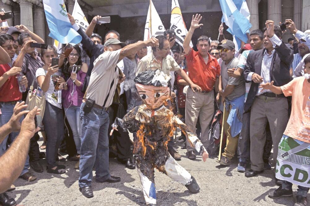 Un grupo de guatemaltecos quema una figura que representa al presidente Jimmy Morales en una protesta para exigir la renuncia del mandatario. (JOHAN ORDONEZ. AFP)