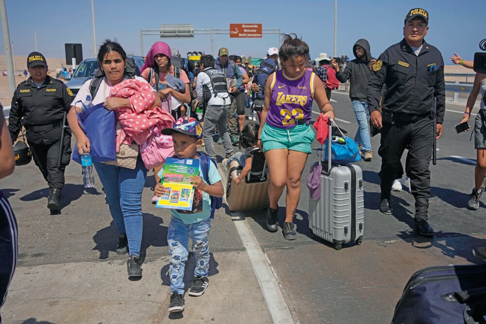 Venezolanos que desean llegar a EU son escoltados por la policía peruana a una oficina migratoria en la frontera con Chile.