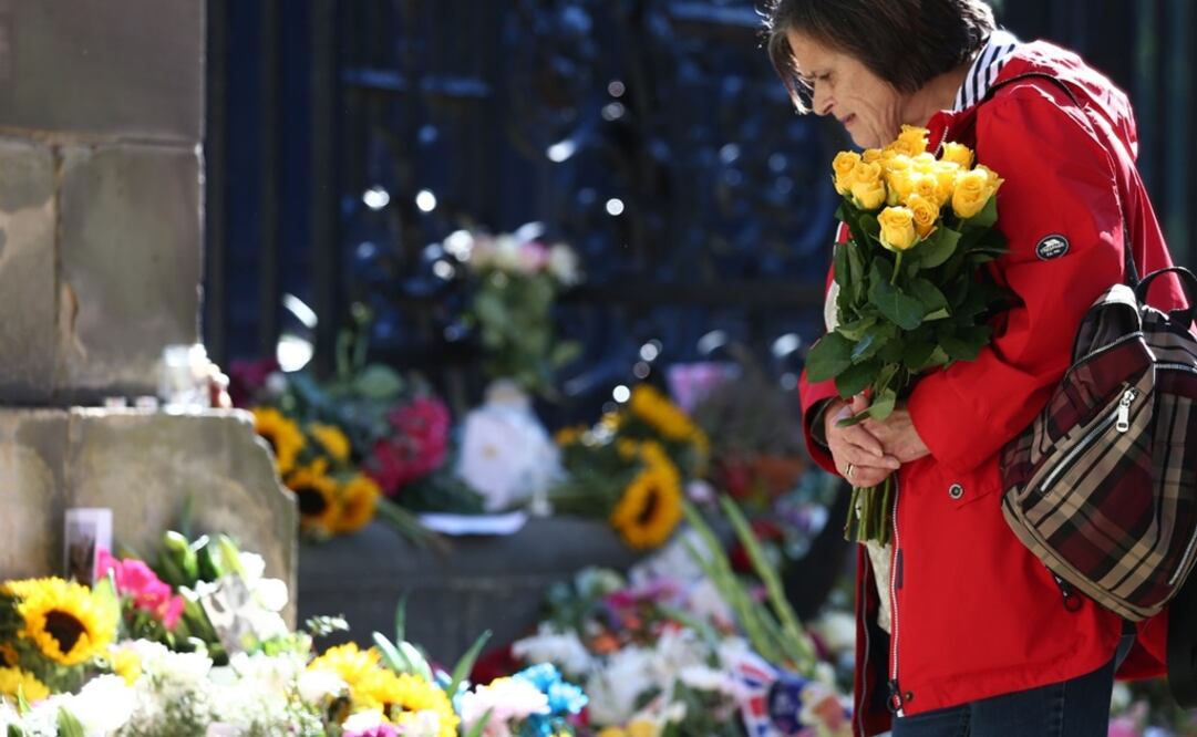 Una persona mira las flores colocadas en honor de la reina Isabel II en Holyrood House en Edimburgo, Escocia. Foto: EFE