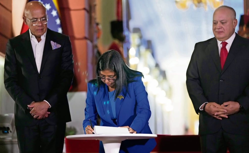 La presidenta encargada Delcy Rodríguez firma el proyecto de Ley de Amnistía; el presidente de la Asamblea Nacional, Jorge Rodríguez (izq.), y el ministro del Interior, Diosdado Cabello, en el Palacio de Miraflores, en Caracas. Foto: Ariana Cubillos / AP