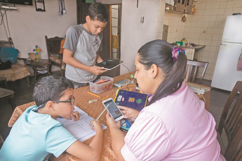 Una mamá ayuda a sus hijos con las tareas, en Caracas, Venezuela. Foto: ARIANA CUBILLOS. AP