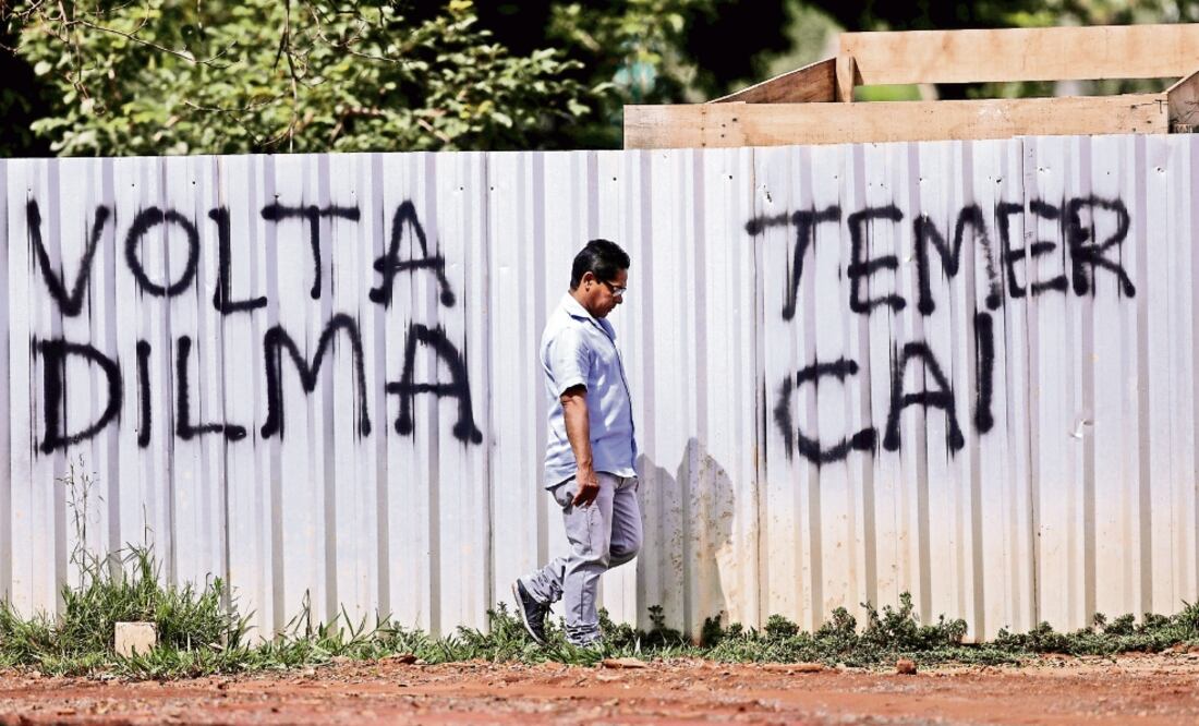 Un hombre camina frente a un grafiti en el que se pide el regreso de la ex presidenta Dilma Rouseff y la caída de Michel Temer (UESLEI MARCELINO. REUTERS)
