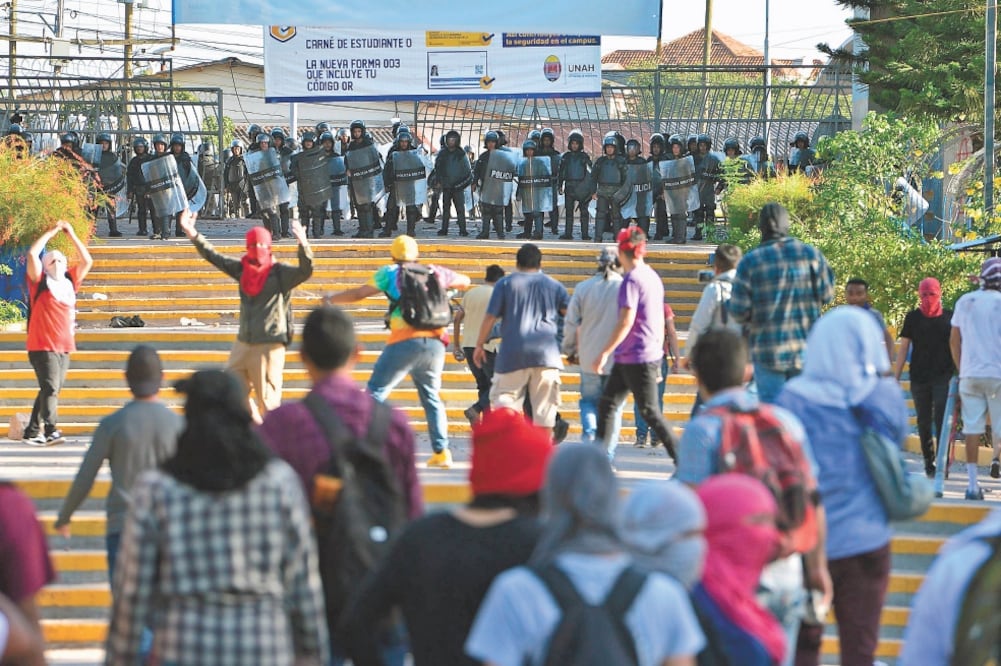 Enojo. Los estudiantes de la UNAH, en Honduras, rechazaron el ingreso al plantel de miembros de la policía militar, a quienes lanzaron piedras. Foto/ORLANDO SIERRA. AFP