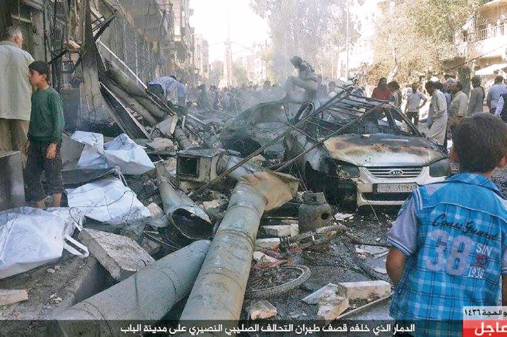 Un grupo afiliado al Estado Islámico divulgó imágenes de edificios y autos destruidos tras los ataques, supuestamente rusos, en Alepo, Siria (AP)