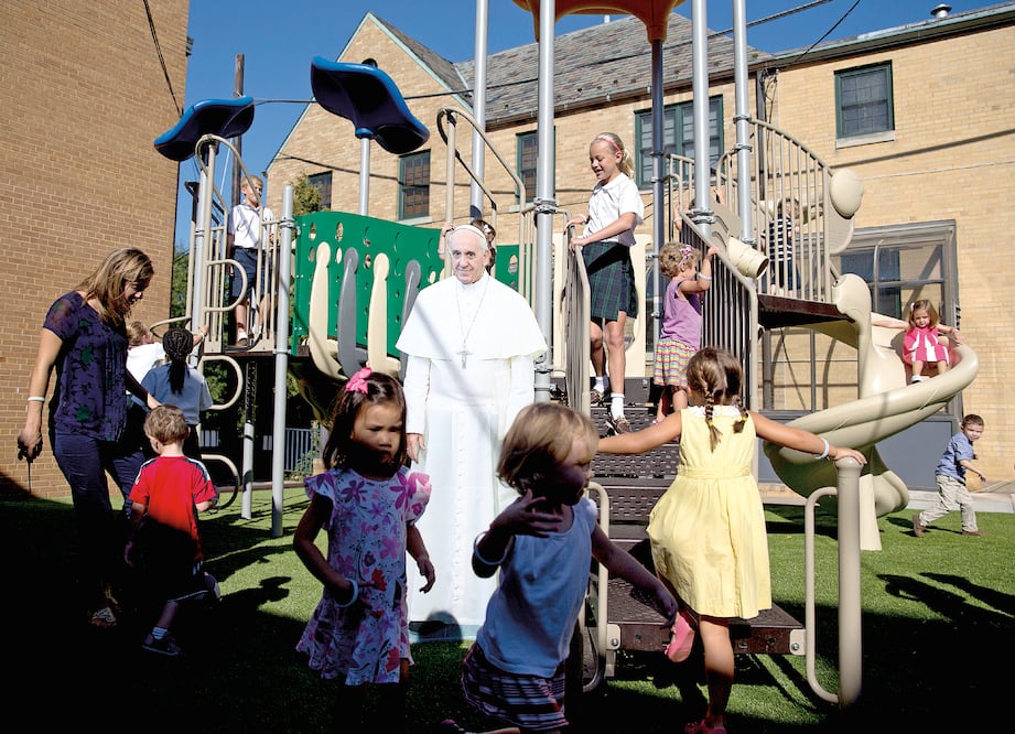 Niños juegan en un patio alrededor de una figura en tamaño natural del papa Francisco en la escuela católica Nuestra Señora de la Victoria, en Washington (CAROLYN KASTER. AP)