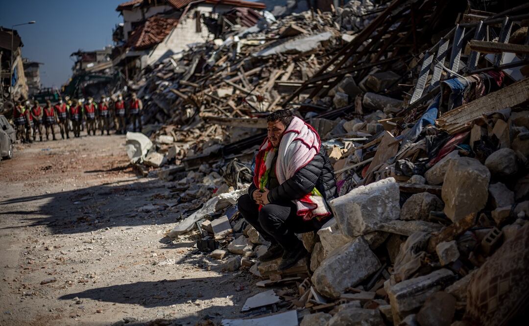 Un hombre espera, sentado entre los escombros de un inmueble que colapsó en los terremotos de la semana pasada en Hatay, Turquía. FOTO: MARTIN DIVISEK. AFP