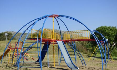 Perrito se divierte en una plaza al tirarse solo por la resbaladilla