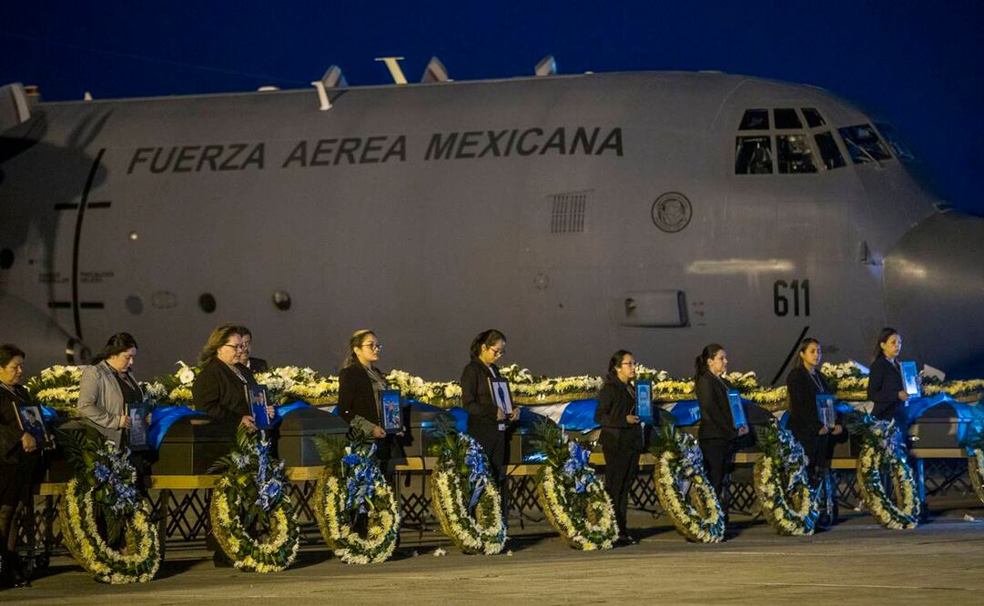 Funcionarias del Ministerio de Exteriores de Guatemala sostienen retratos mientras permanecen junto a los cuerpos de los migrantes fallecidos en México y repatriados hoy a Ciudad de Guatemala (Guatemala). Las autoridades de Guatemala recibieron este martes los cuerpos de 17 de los 19 guatemaltecos que murieron hace dos semanas en el incendio que mató a 40 migrantes en una estación del Instituto Nacional de Migración (INM) mexicano en Ciudad Juárez, en la frontera con Estados Unidos. EFE/ Esteban Biba