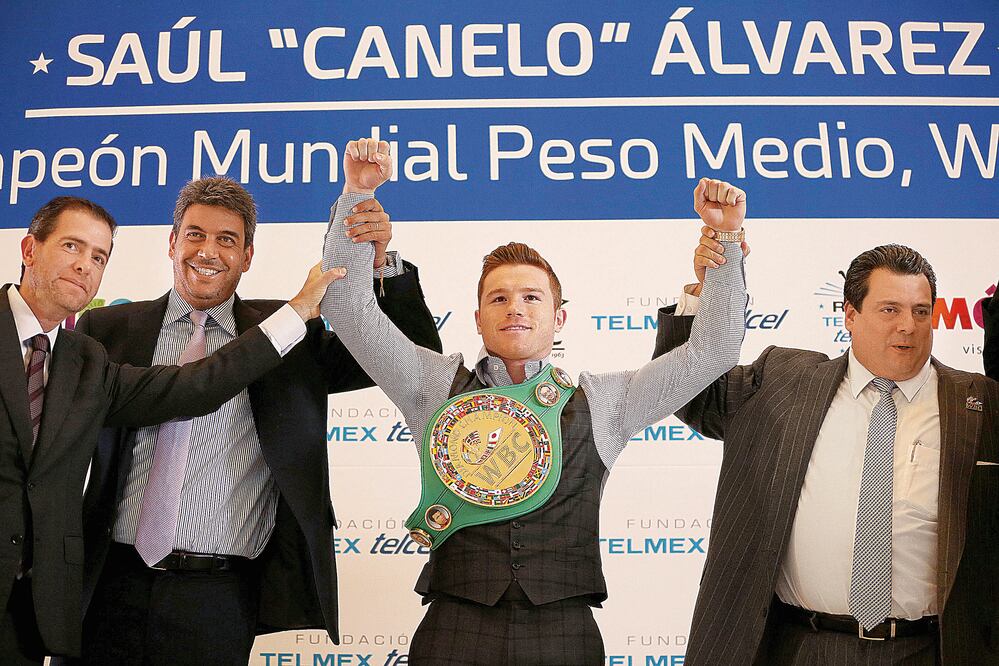 Arturo Elías Ayub y Mauricio Sulaimán levantan los brazos del campeón de los medianos CMB, Saúl Álvarez (FOTOS: JUAN CARLOS REYES GARCÍA. EL UNIVERSAL)