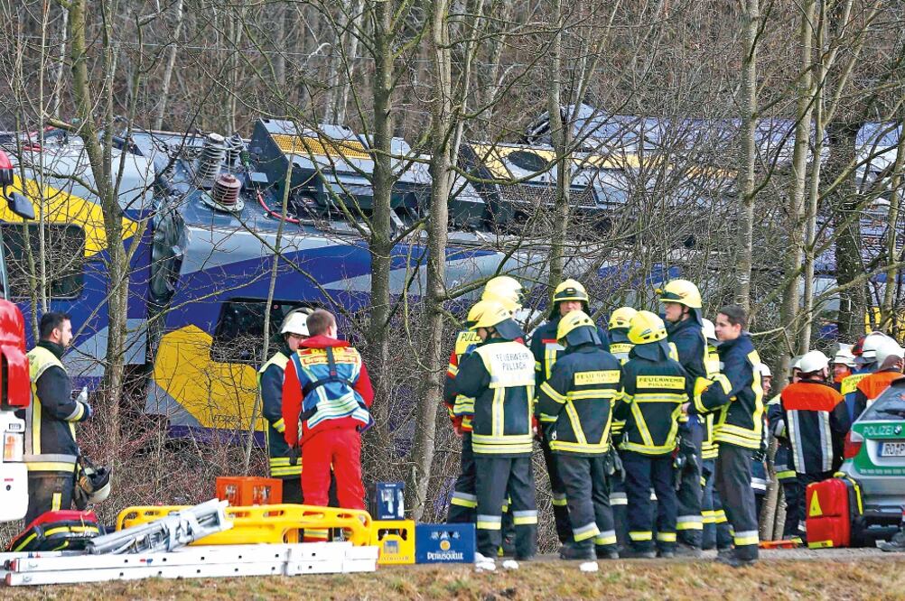 Miembros de los servicios de emergencia asisten en las labores de rescate en la zona donde colisionaron los trenes, cerca de Bad Aibling, Alemania (MICHAEL DALDER. REUTERS)