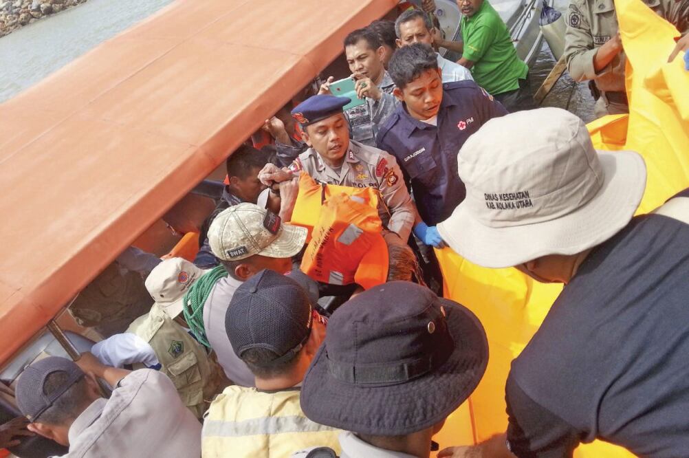 Apoyo. El cuerpo de una de las víctimas es desembarcado por rescatitas y habitantes de Kolaka, en Sulawesi, Indonesia (ANTARA FOTO. REUTERS)