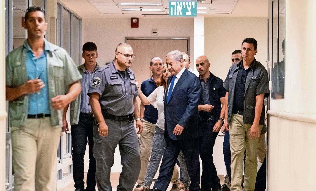 El premier israelí Benjamin Netanyahu (centro) y su escolta, tras visitar aye r a Shimon Peres, en la clínica Sheba, en Tel Aviv (JACK GUEZ. REUTERS)
