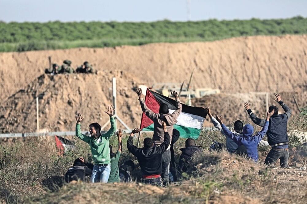 Palestinos ondearon ayer banderas durante un enfrentamiento con las tropas israelíes en la división entre Gaza e Israel (MOHAMMED SABER. EFE)