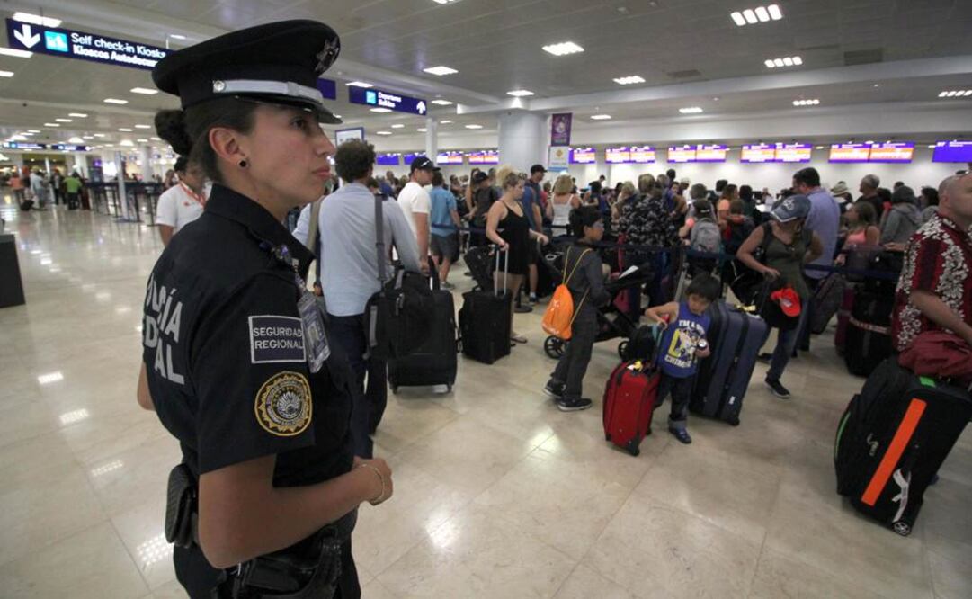 Una mujer de la Policía Federal realiza labores de vigilancia en el aeropuerto de Cancún, Quintana Roo Foto: EFE
