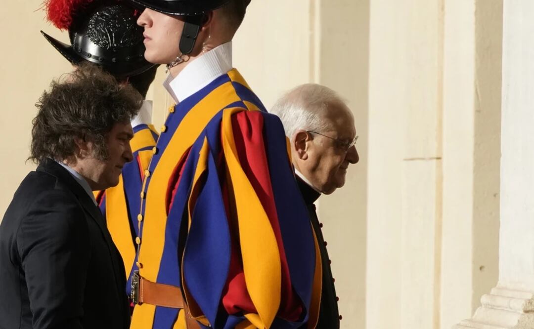 El presidente argentino Javier Milei, se ve precedido por el jefe de la casa papal, el obispo Leonardo Sapienza, entre dos guardias suizos en el Patio de San Dámaso en el Vaticano, a su llegada para una audiencia con el papa Francisco. Foto: AP