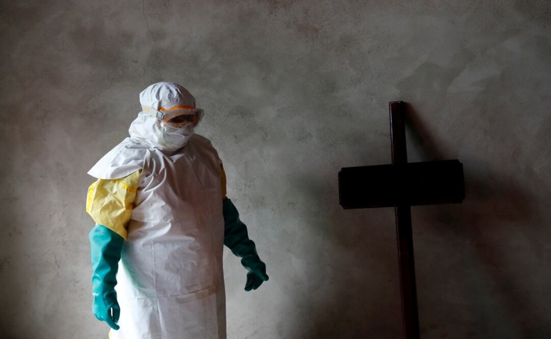 A healthcare worker stands next to a cross during a funeral of a person who is suspected of dying of Ebola in Beni, North Kivu Province of Democratic Republic of Congo - Photo: Goran Tomasevic/REUTERS