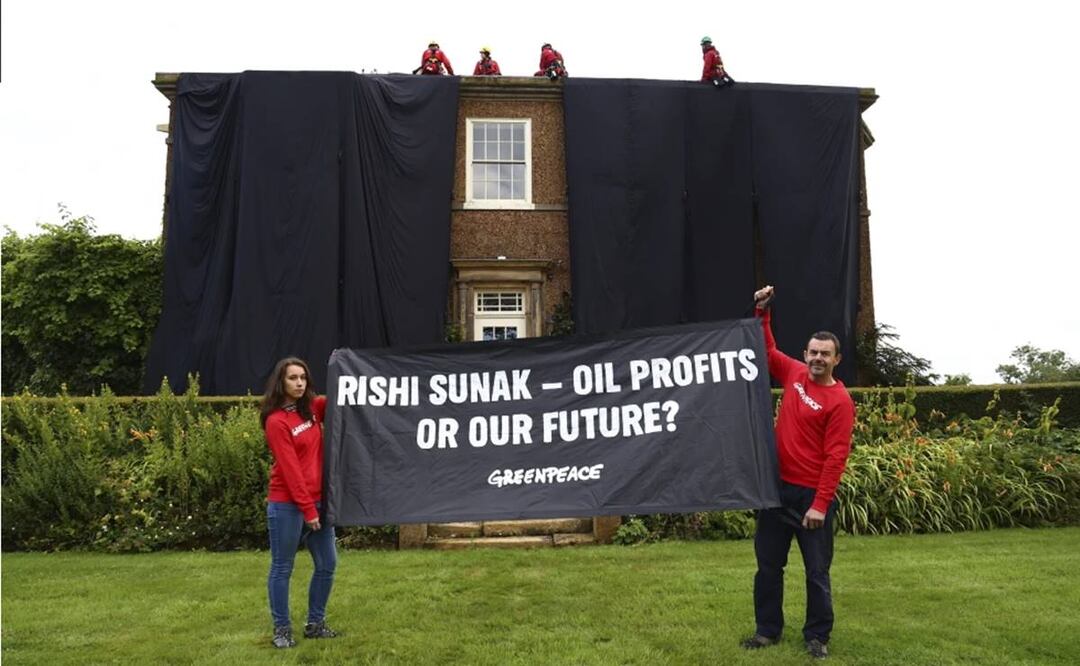 Activistas posan con una pancarta delante de la casa palaciega del primer ministro de Gran Bretaña, Rishi Sunak, en Yorkshire, Inglaterra. Foto: AP
