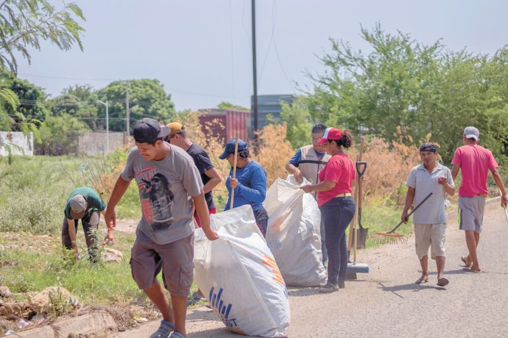 En Ciudad Ixtepec, 152 migrantes que esperan la resolución de su solicitud de asilo en México; realizan tareas de limpieza a las orillas del tren, para el programa de Emergencia Social, de la Secretaría del Bienestar. Foto/CLAUS MENDOZA. EL UNIVERSAL