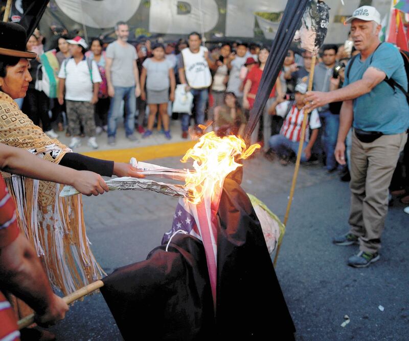 Protesta. Seguidores de Evo Morales quemaron una bandera estadounidense en la embajada de EU, en Argentina. Foto/AGUSTIN MARCARIAN. REUTERS