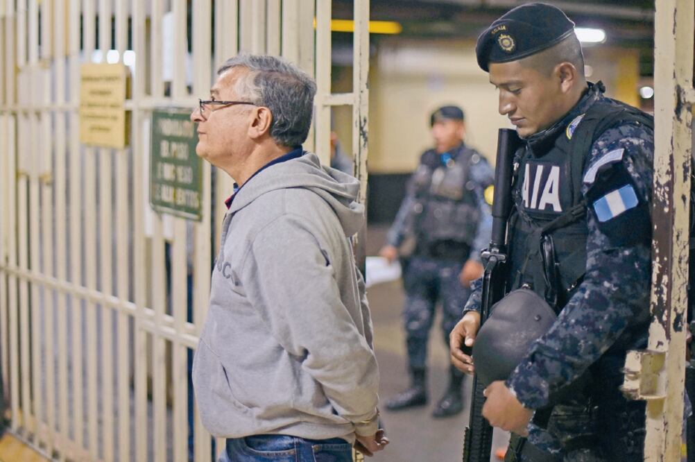 Policías escoltan a Rudy Villeda, ex jefe de la Superintendencia de Admnistración Tributaria (SAT) de Guatemala, tras ser arrestado (JOHAN ORDOÑEZ. AFP)