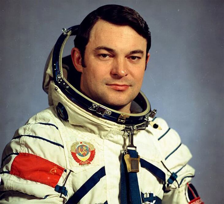 Yuri Romanenko usando el traje espacial con las insignias de la Unión Soviética. Durante su carrera como cosmonauta estuvo en el espacio tres ocasiones, la tercera siendo su última misión espacial batió el récord de permanencia más larga en el espacio.