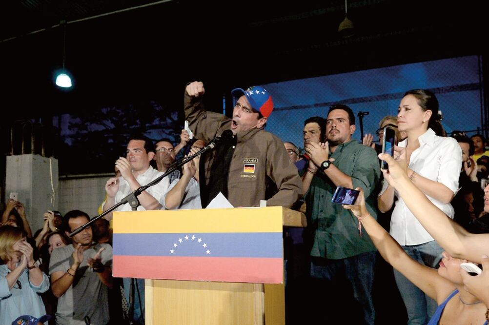 El gobernador de Miranda y opositor Henrique Capriles, durante la conferencia que dio ayer en Caracas, acompañado de otros líderes, como Corina Machado (der.) (FEDERICO PARRA. AFP)