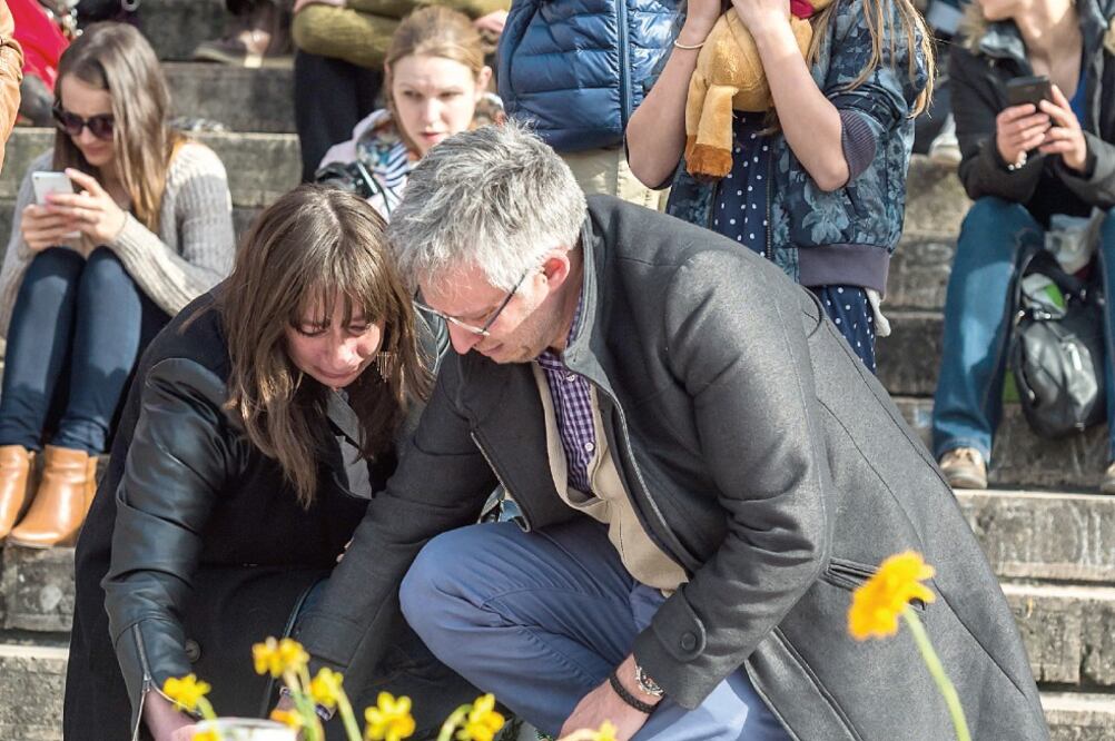 La gente coloca flores y velas en el memorial instalado en la Plaza de la Bolsa, en Bruselas, en honor a las víctimas de los atentados del martes. Una manifestación convocada para hoy fue cancelada por cuestiones de seguridad (GEERT VANDEN WIJNGAERT. AP)