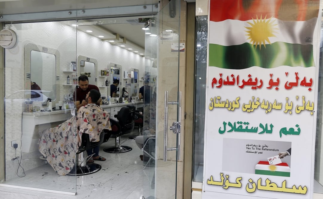 Vista de un cartel llamando a votar en el referéndum de independencia de Kurdistán junto a una peluquería en Erbil, región kurda al norte de Irak (Foto: EFE)