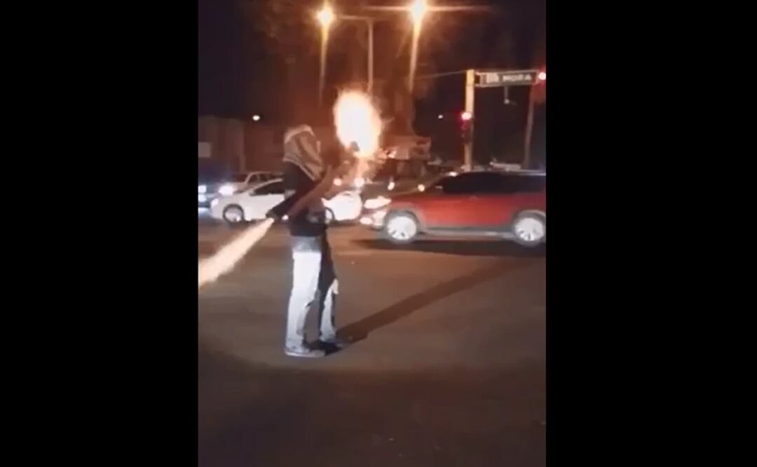 El joven aparece con una vestimenta tipo árabe, con la cabeza cubierta y acciona su arma de fuego. Foto: Captura de video 