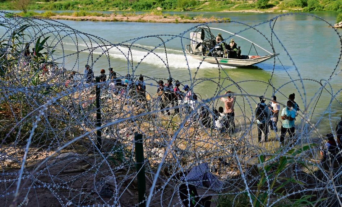 Migrantes que cruzaron desde la frontera mexicana esperan en Eagle Pass, Texas. Foto: AP