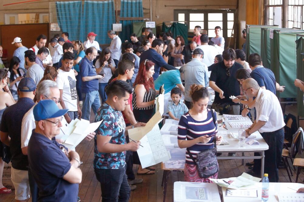 Decenas de personas acudieron ayer a las mesas de votación para participar en la jornada de elecciones presidenciales y parlamentarias en Santiago, Chile (ELVIS GONZÁLEZ. EFE)