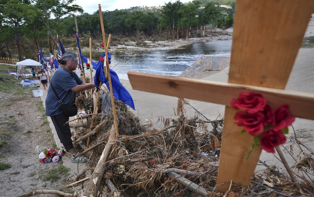 Len Arredondo coloca flores en un monumento improvisado para las víctimas de las inundaciones, instalado a orillas del río Guadalupe, en Kerrville, Texas, el sábado 12 de julio de 2025. Foto: AP