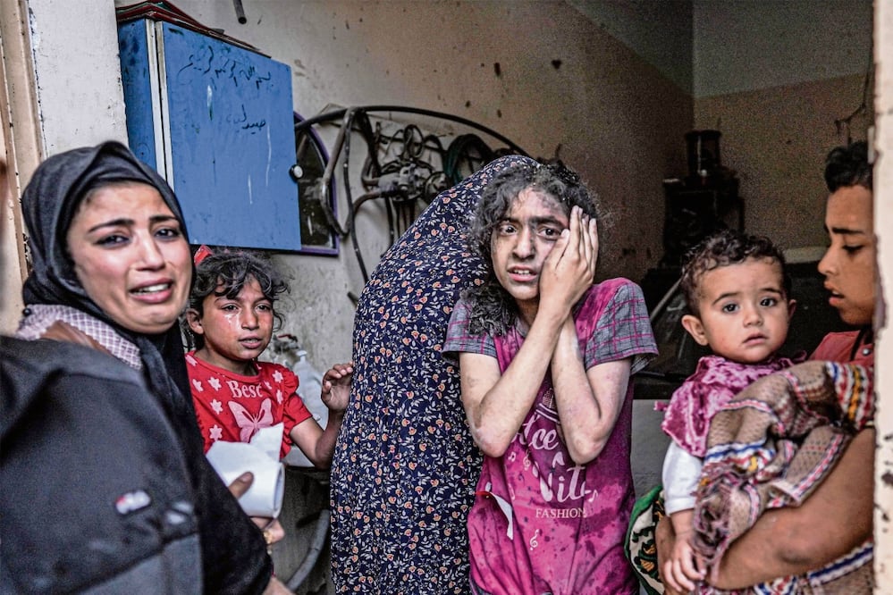 Una mujer y niños reaccionan tras un bombardeo israelí en Nuseirat, en el centro de la Franja de Gaza, en medio del conflicto contra Hamas. Foto: AFP