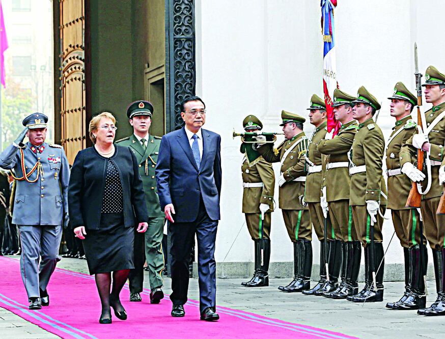 El primer ministro de China, Li Keqiang y la presidenta de Chile, Michelle Bachelet, pasan revista a la guardia de honor durante la ceremonia de bienvenida al premier, en Santiago, capital chilena, el pasado 25 de mayo (DING LIN / XINHUA)