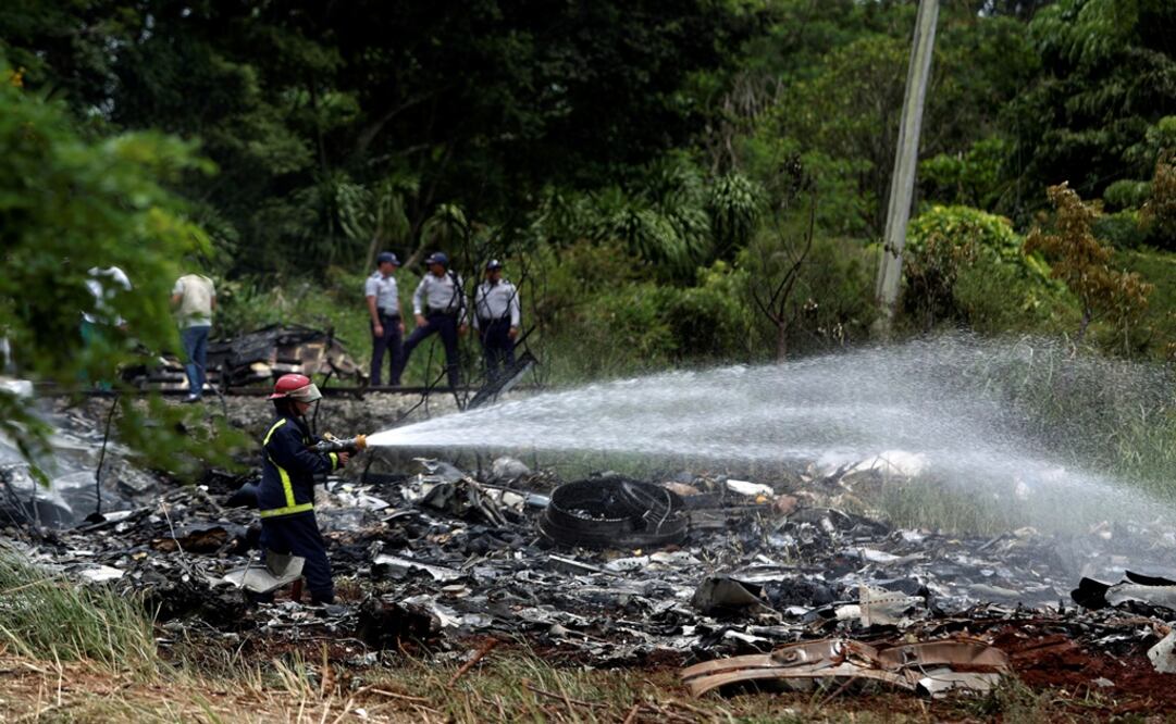 Firefighters work in the wreckage of a Boeing 737 plane that crashed in the agricultural area of Boyeros, around 20 km south of Havana, shortly after taking off - Photo:Alexandre Meneghini - REUTERS