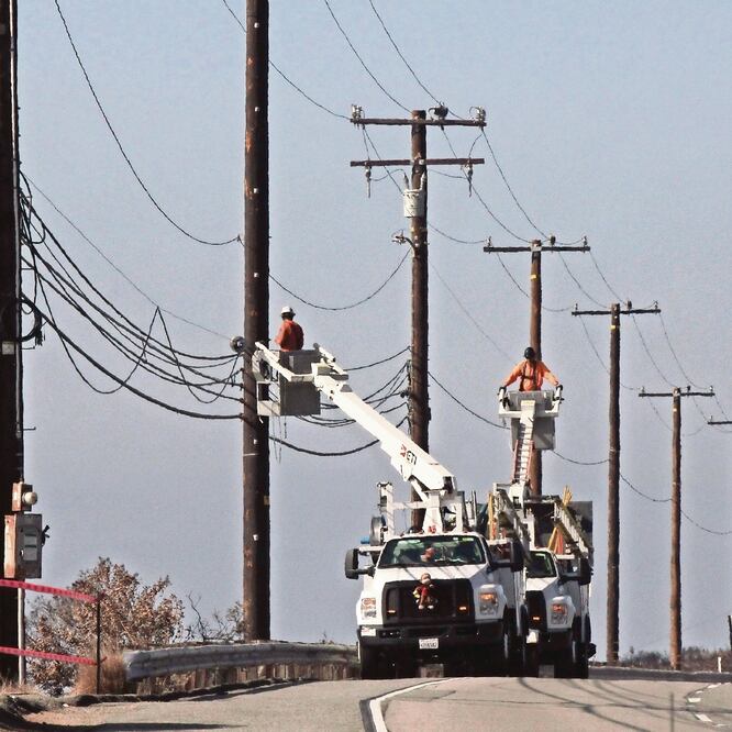 Cuadrillas de servicios públicos reparaban ayer el cableado en la autopista Pacific Coast, al oeste de Malibú, California, tras el paso del incendio Woolsey