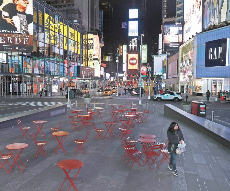 Una mujer camina por Times Square, en Nueva York, el lunes pasado. A partir de mañana por la noche, la actividad se detendrá casi por completo. Foto: SETH WENIG. AP