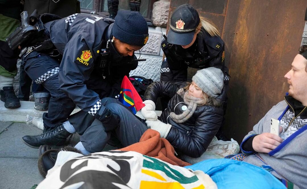 Mujeres policías se llevan a la activista climática sueca Greta Thunberg mientras se manifestaba con otros activistas frente al Ministerio de Finanzas. Foto: AFP 