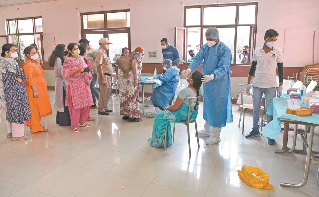 Un empleado sanitario realiza una prueba para detectar coronavirus en empleados del Instituto de Investigación Agrícola de India, en Nueva Delhi. Foto: PRAKASH SINGH. AFP