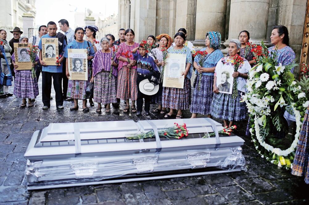 Activistas y familiares de desaparecidos durante la guerra civil en Guatemala protestan alrededor del féretro que contiene los restos de Jacobo Pérez, los cuales fueron recuperados recientemente (SAUL MARTINEZ. REUTERS)