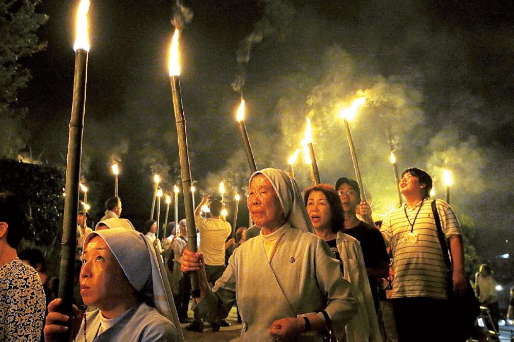 Católicos con antorchas salen de la catedral de Urakami en una marcha hacia el Parque de la Paz en Nagasaki, en el 70 aniversario del bombardeo atómico (TORU HANAI. REUTERS)
