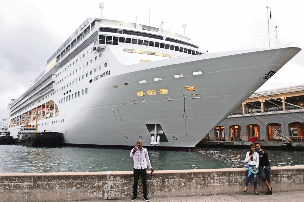 Cubanos enfrente del crucero MSC Opera, en La Habana. El gobierno de Raúl Castro difundió ayer medidas migratorias relacionadas con viajes marítimos (ALEXANDRE MENEGHINI. REUTERS)