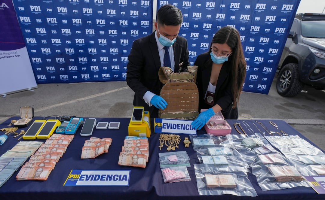 Agentes de la PDI muestran objetos decomisados tras un operativo contra una célula del Tren de Aragua. (02/06/2026) Foto: AP