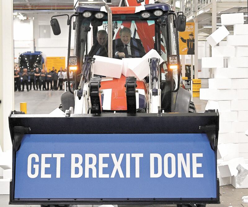 El premier británico Boris Johnson conduce una excavadora JCB con una leyenda a favor de la salida británica de la Unión Europea, en un mitin de campaña en Uttoxeter. REUTERS