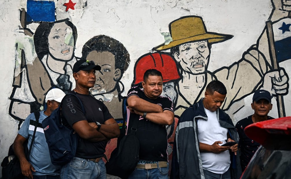 Trabajadores esperan afuera de la Asamblea Nacional a que los líderes sindicales emerjan con los resultados de sus reuniones con legisladores en la Ciudad de Panamá. Foto: AFP