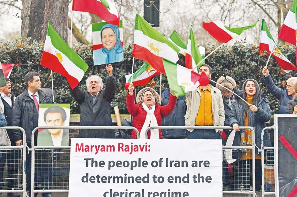 Manifestantes ondean banderas iraníes afuera de la embajada de Irán en Londres, en apoyo a las protestas contra el régimen del presidente Hassan Rouhani (BEN STANSALL. AFP)